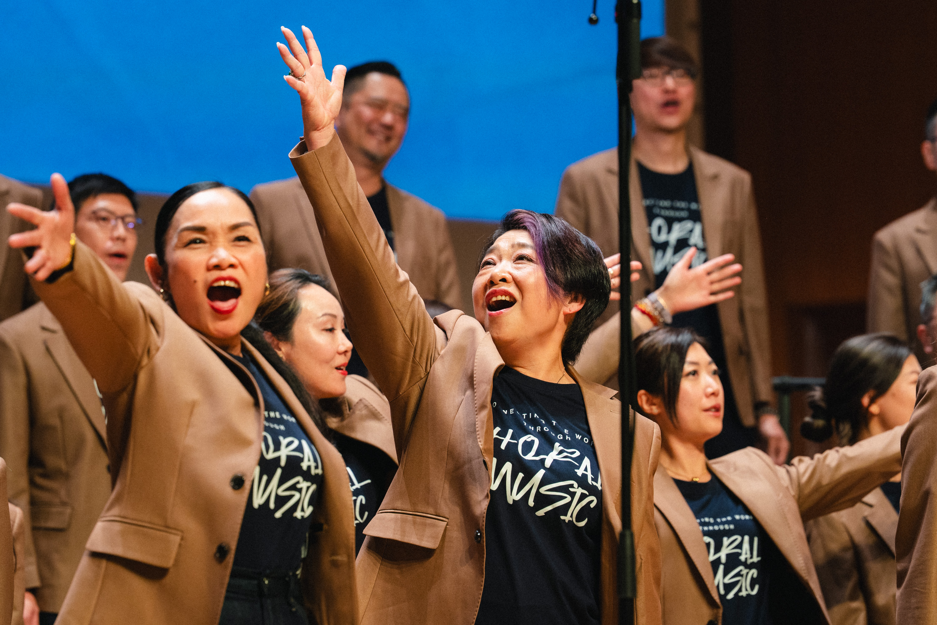 HKVC singers celebrating with raised arms on stage