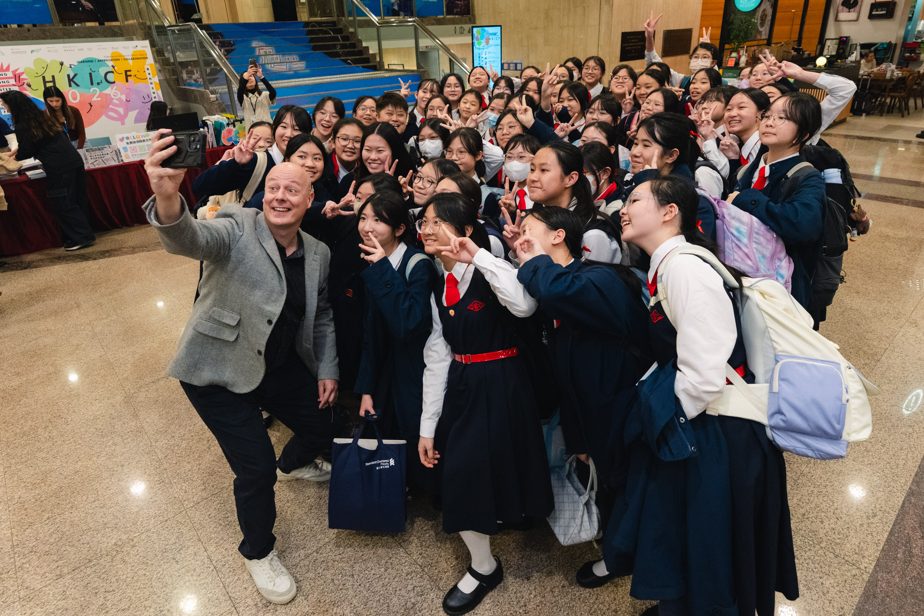 A conductor and school choir members celebrating together after an HKVC event